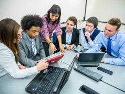 Business students and faculty looking at something on an Ipad