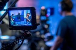 Photo of camera viewfinder showing a round table of pundit students